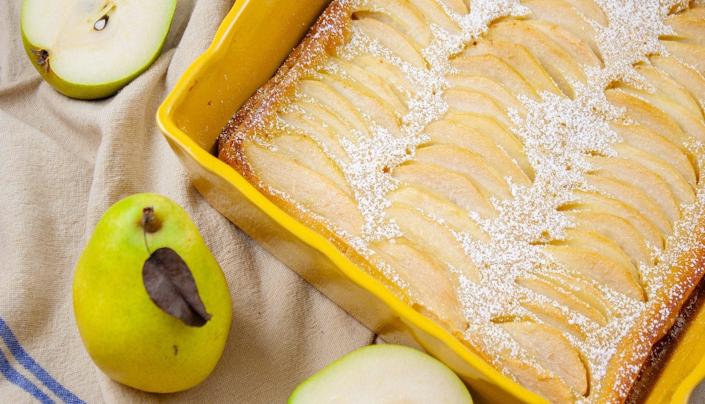 This is a picture of a pear clafoutis in a yellow baking dish